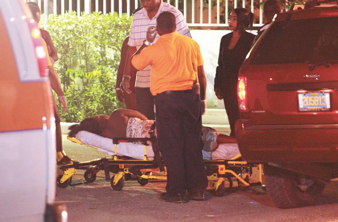 An injured woman is taken to hospital after the shooting.
