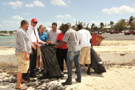 Richard Lightbourn, FNM candidate for Montagu, helps residents clean Montagu Beach.