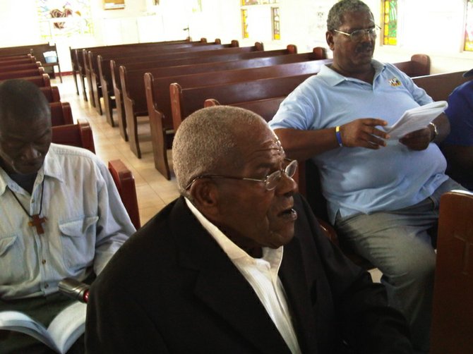 Mr Israel 'Bonefish Foley' Rolle is seen during his Confirmation Service at St Mary Magdalene Anglican Church in West End, Grand Bahama, which was presided over by the Anglican Bishop Rt Rev Laish Z Boyd. In the background is businessman Mr Artis Neely, a close friend of Bonefish Foley.