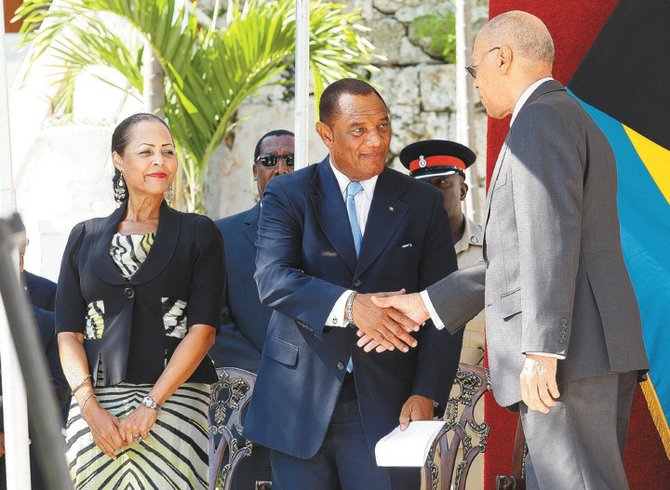 Prime Minister Perry Christie shakes hands with Governor General Sir Arthur Foulkes as his wife, Bernadette, looks on.