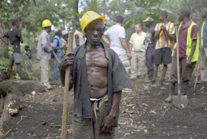 In this April 10, 2012 photo, Genove Valcimon, 70, poses for a picture as he works on a road being built through the mountains to lead to an exploratory drill site in the department of Trou Du Nord, Haiti. (AP)