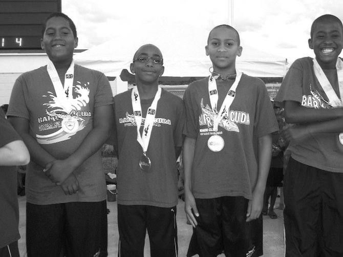 RECORD BREAKERS: Shown (L-R) are Shamar St. Rose, Samuel Gibson, Izaak Bastian, and Christopher Neil on the medla podium after winning the 9-10 boys 200m medley relay. They set a new Bahamas, Open and National record.