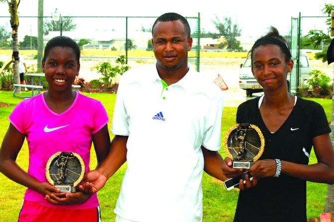 14S WINNERS: BLTA president Derron Donaldson presents the awards to the ITF Junkanoo Bowl doubles champions Gabriela Donaldson (right) and Iesha Shepherd. The duo defeated the team of Kianah Motosono and Eva Frazzoni 6-2, 4-6, 6-3 in a three-set thriller.