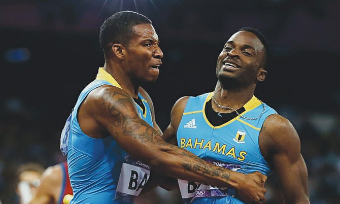 MAGIC MOMENT: Ramon “Fearless” Miller (right), who ran the anchor leg on the 4x400m relay team that won gold at the London Olympics, is embraced by teammate Demetrius Pinder after their victory. With the win, the Bahamas vaulted to 50th among the 204 countries that competed. (AP)                                                                                                     
