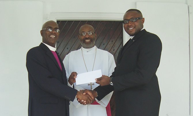 James Palacious, Bishop Laish Boyd, The Reverend Tellison Glover at a cheque presentation for St. Philips Anglican Church.