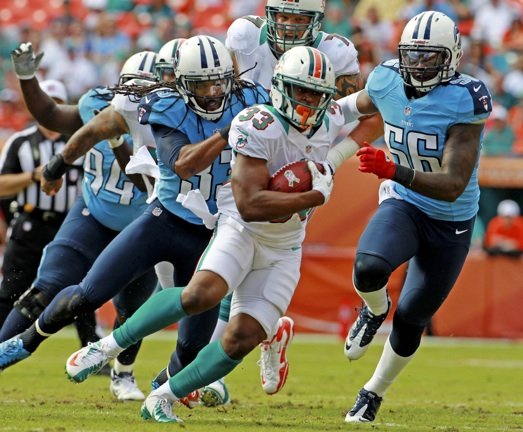 Miami Dolphins' Daniel Thomas (33) is chased down by Tennessee Titans' Michael Griffin (33) and Akeem Ayers (56) during the third quarter of their NFL football game, Sunday, Nov. 11, 2012, in Miami. The Titans won 37-3. (AP)