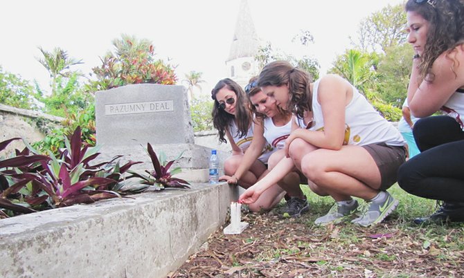 Students light a candle in the Jewish cemetery near St Mathews on Shirley Street. 
