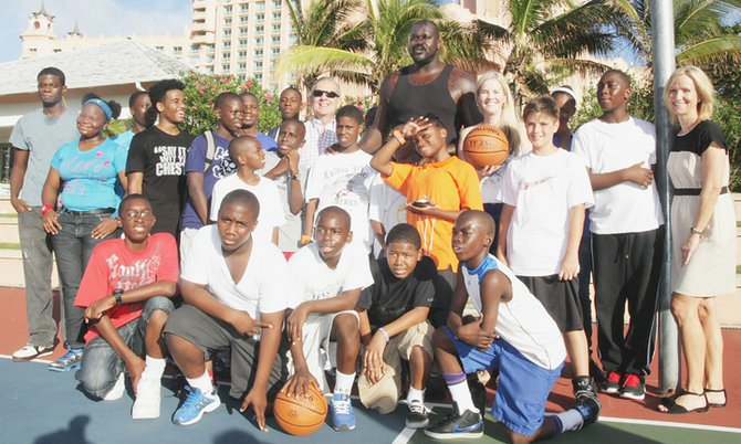 Shaquille O'Neal takes pictures with children at the basketball court at Atlantis Saturday afternoon.