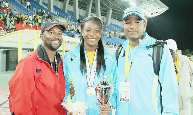 TRIPLE GOLD GLORY: Shown (l-r) are coach George Cleare, Shaunae Miller and her father Shaun Miller after she won the Austin Sealy Award at the 2013 BTC Carifta Games.                                                   Photo by Tim Clarke/Tribune Staff
