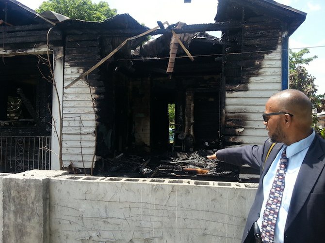 Rodney Moncur points at the remains of his home. 