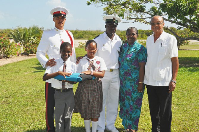 Proud Carlton Cartwright holds the flag along with his schoolmate Perica Carroll. Also in the picture are National Independence Secretariat Commissioner Dr Linda Moxey-Brown; Constable Gilbert Knowles of the RBPF, Petty Officer Gladstone Moss of the RBDF and far right is Jordan Ritchie.