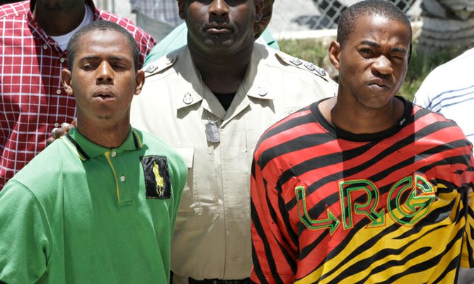 Antonio Bowe (left) and Leon Chase (right) being escorted to Magistrates’ Court yesterday afternoon. 