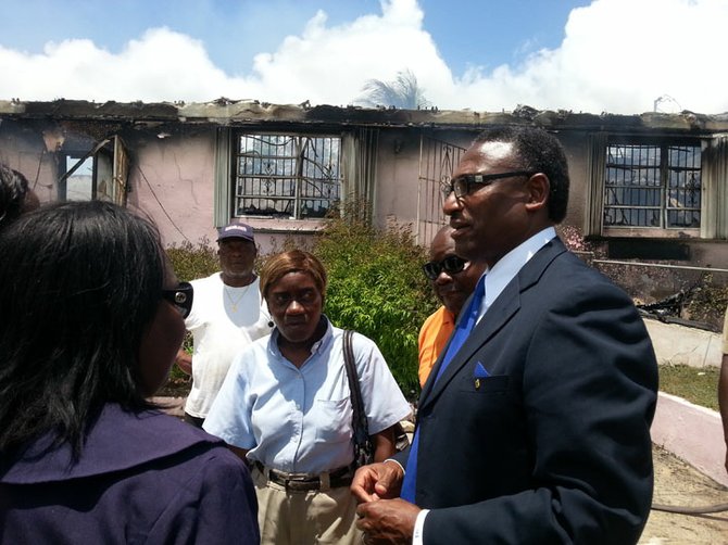 Minister of Local Government V Alfred Gray at the remains of the complex.