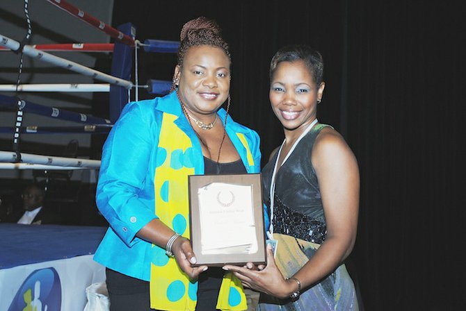 MICHELLE MINUS (left) receives a plaque from Makeva Wallace, of Buttons Formal Wear.
