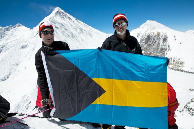 COLUMBUS might have discovered the Bahamas, but wherever Harry McPike goes so goes the Bahamas flag to be planted on mountain peaks, both at the top and bottom of the world – in Africa, South America and now in the Himalayas. The flag is donated by Mr Peter Bates, “The Sign Man” on Shirley Street, and to date flies from a 23,100 ft peak in the Himalayas, 19,341 ft Mt Kilimanjaro in Tanzania, the 20,720 ft Mt Chimborazo in Ecuador. Last year it even made it to the South Pole. Shown here on April 26 this year are Mr Peter Wirth (left) senior relationship manager of Credit Suisse, and Mr McPike on the 23,100 ft Lhakpa-Ri peak with Mt Everest in the background.
