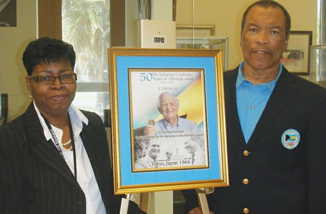 Dr Berthamae Walker accepts a portrait of Sir Durward Knowles from BOC president Wellington Miller to put on display in the Harry C Moore Library.
