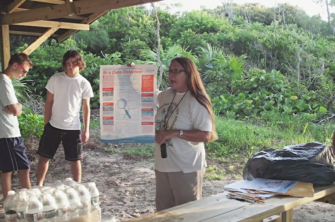 Gail Woon, of EARTHCARE, explaining data cards for international coastal clean-up. 
