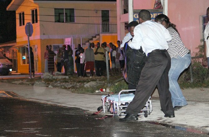 The body of a 17-year-old boy who was stabbed in the back and head and died of his wounds is removed from the scene at Baillou Hill Road last night. Photo: Tim Clarke/Tribune Staff
