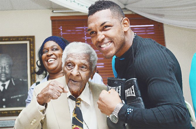 Newly crowned WBC Continental of Americas middleweight champion Tureano Johnson shares a special moment with his grandfather Nathaniel “Piccolo” Saunders.
                                                                                         Photo by Lamond Johnson/Tribune Staff