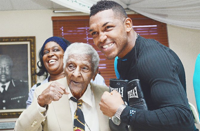 Newly crowned WBC Continental of Americas middleweight champion Tureano Johnson shares a special moment with his grandfather Nathaniel “Piccolo” Saunders.
                                                                                         Photo by Lamond Johnson/Tribune Staff