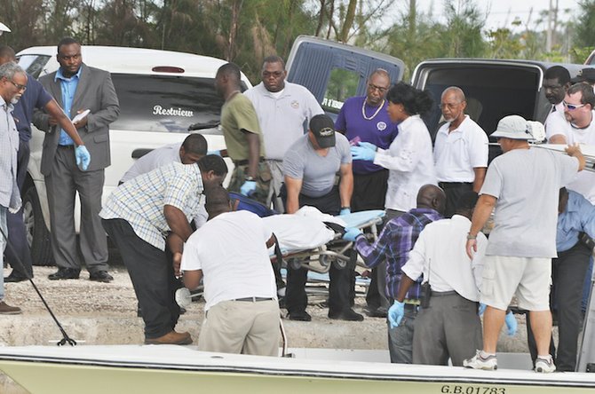 Rescuers who hurried to the scene discovered four people had died. Here, one of the bodies is loaded on to the dock. Photos: Vandyke Hepburn
