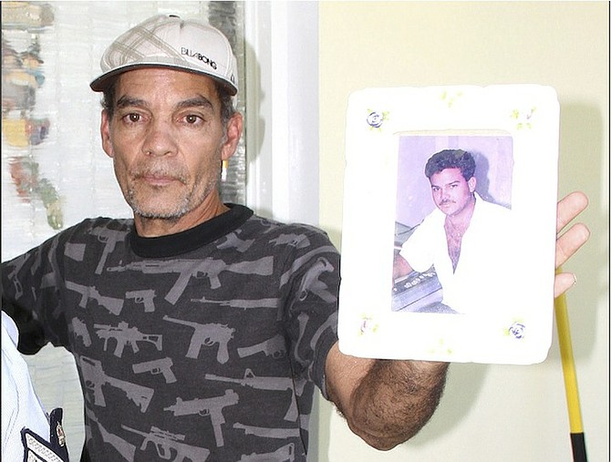 A family member holds up a picture of 44-year-old Andre Cartwright at his Blair Estates home yesterday.

Photo/Tim Clarke/Tribune staff