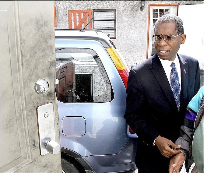 Haitian Ambassador Antonio Rodrigue shows where thieves damaged a door.
