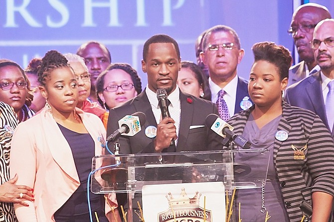 Chairo Munroe speaks to the delegates at the end of the convention in Grand Bahama yesterday to thank them for their love and support following the death of his parents, Dr Myles Munroe and his wife Ruth, and seven others in a plane crash. Chairo’s sister, Charissa, stands at his side during the speech, wearing a peach jacket, left. Photo: David Mackey
