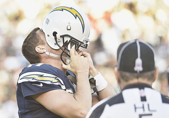 Chargers quarterback Philip Rivers hides his face in his helmet as he displays his frustration during the second half of the Chargers’ 13-6 victory over the Oakland Raiders.
                                                                                                                          (AP Photo/Denis Poroy)
