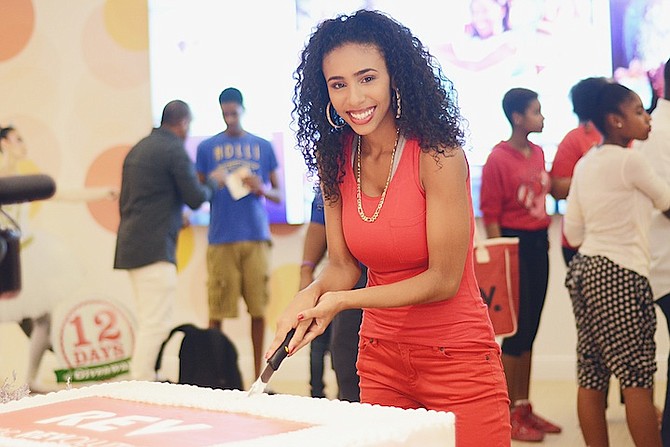 Angelique Sabrina, Bahamian pop artist and face of Cable Bahamas, cuts a cake to declare the new Cable Bahamas store open.
