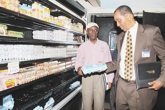 E J Bowe, newly-appointed chairman of the Price Control Commission, is pictured at right inspecting the cost of eggs at a local grocery store. Photo: Letisha Henderson/BIS