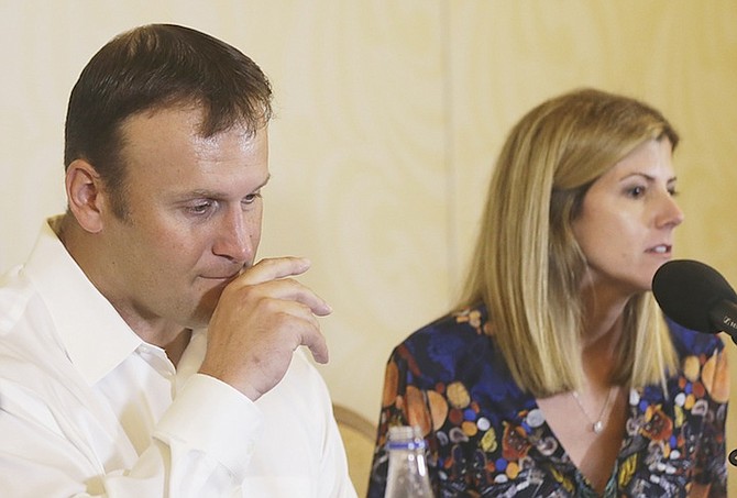 Former Miami Dolphins fullback Rob Konrad, left, with his wife Tammy during a news conference where he told of his ordeal after he fell off his boat nine miles from shore while fishing last week off the South Florida coast. Inset right, Konrad in 2001 scoring for the Miami Dolphins. 