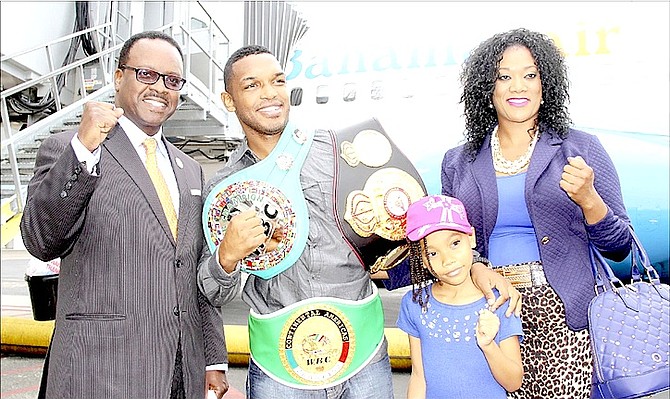 THE CHAMP: Minister of Youth, Sports and Culture Dr Daniel Johnson (far left) greets Tureano Johnson, his wife and daughter on their arrival at the Lynden Pindling International Airport yesterday.