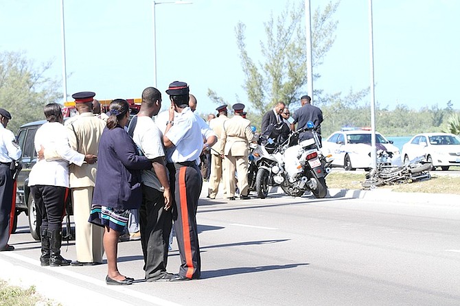 Family members look on as officers collect evidence after Rio Demeritte was killed when his motorcycle crashed into a utility pole on John F Kennedy Drive. 