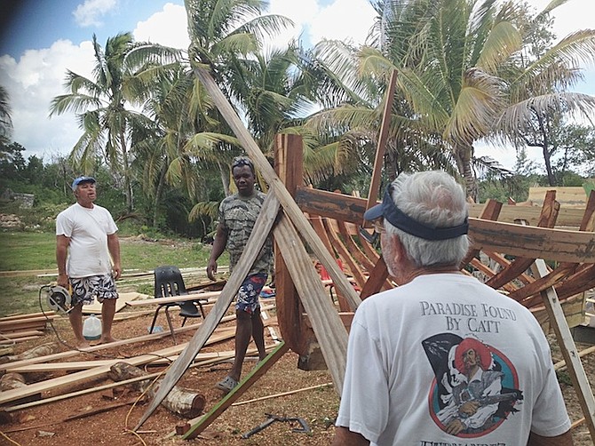 Tourists watch as a racing sloop is constructed at the New Bight regatta site. Builder Mark Knowles explained that most traditional boat builders have passed away, and there was little interest among the younger generation to learn the craft.	Photos: Ava Turnquest/Tribune Staff
