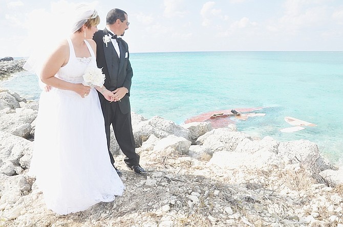 Deborah Fause and Lenny Piciullo look at the wreckage of their boat, which sank off West End last week, throwing their wedding plans into disarray. However, their wedding went ahead when they were helped by the Ministry of Tourism and the staff of Old Bahama Bay. 
Photo: Andrew Miller/BIS