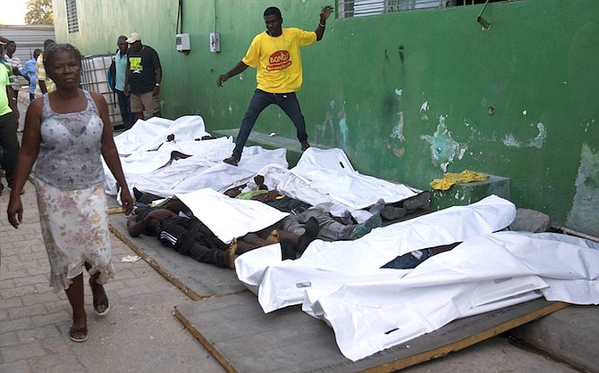 A woman walks away from bodies after failing to find a missing family member among them outside the morgue at the General Hospital in Port-au-Prince, Haiti, Tuesday.
(AP Photo/Dieu Nalio Chery)
