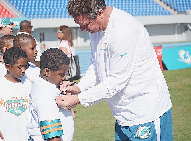 Dan Marino autographs youngsters’ shirts at his flag football youth clinic. 
