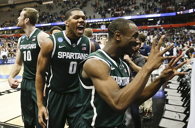 Michigan State's Marvin Clark Jr. (0) celebrates as he leaves the court with teammates Matt Costello (10) and Lourawls Nairn Jr. after Michigan State defeated Oklahoma 62-58. (AP Photo/Seth Wenig)
