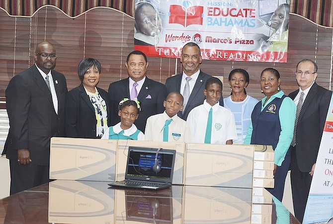 Prime Minister Perry Christie is joined by Minister of Education Jerome Fitzgerald and Minister of the Environment and Housing Kenred Dorsett to present computers to pupils.