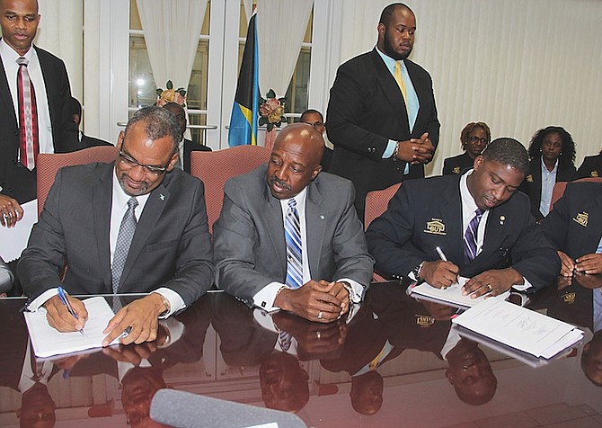 An Industrial agreement was signed between the Government of The Bahamas and the Bahamas Union of Teachers yesterday by Minister of Education, Science and Technology Jerome Fitzgerald, left, and union vice-president Zane Lightbourne.  Watching is Minister of Labour Shane Gibson.  

Photo: Letisha Henderson/BIS
