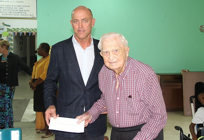 MARK Holowesko (left) presents Sir Durward Knowles with a $100,000 cheque on Friday at the Bahamas Association for the Physically Disabled centre at Dolphin Drive. Photo: Tim Clarke/Tribune Staff
