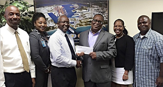 From left Lucian Laing, Freeport Container Port Director, Channan Jones, Grand Bahama Airport Co. Director, Godfrey Smith, CEO, Freeport Harbour Company, Freeport Container Port and Grand Bahama Co, Ken “Motorboat” Ferguson, Leader of New Life Classic Dancers Junkanoo Group, Sherry Brookes, PA/Corporate and Government Affairs Director, Freeport Harbour Company, Freeport Container Port and Grand Bahama Airport Co, and Rico Lewis, Executive Member, New Life Classic Dancers Junkanoo Group at the donation presentation at Freeport Container Port.
