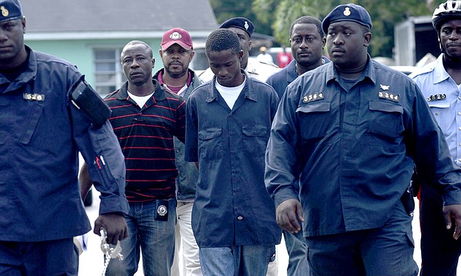 Mackenzy Dorestin is taken into Magistrates Court after being arraigned for threatening to kill police officers in social media postings. Photo: Shawn Hanna/Tribune Staff
