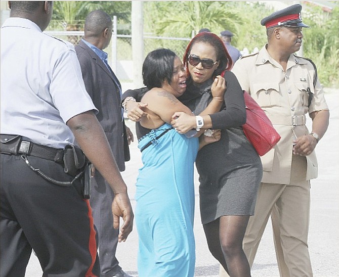 Khandi Gibson, left, is comforted by a friend after her boyfriend, Roberto ‘Bonaby’ Williams was shot dead yesterday. Photo: Tim Clarke/Tribune Staff