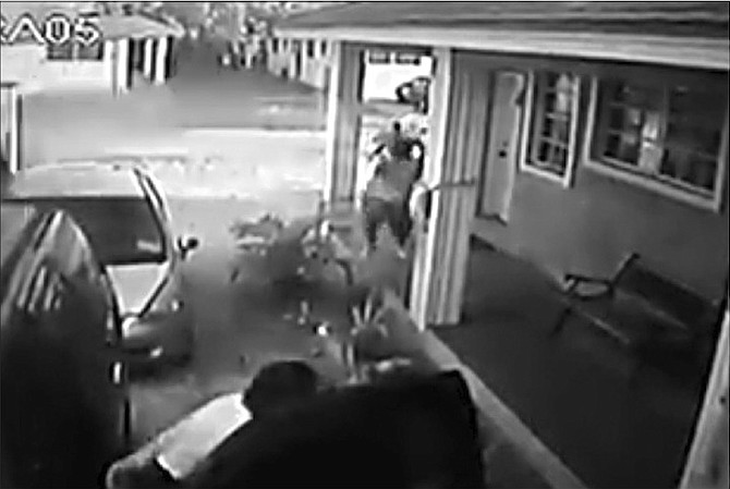 A screenshot from security camera footage showing the moments before Roberto Williams was shot dead outside his home, with two gunmen rushing towards him. 