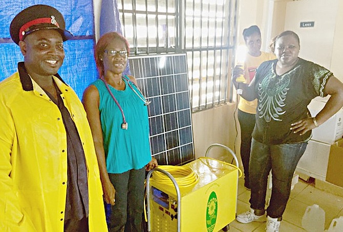 Local nurses with the solar powered generator that will allow medical supplies such as insulin to be refrigerated as well as power the airport terminal.
