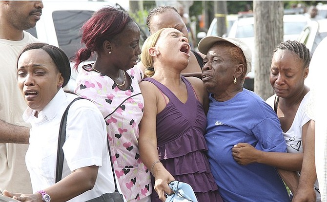 Family members and friends were left in tears yesterday at the scene of the country’s latest murder, in Dorsett Street, Fox Hill. Photo: Tim Clarke/Tribune Staff