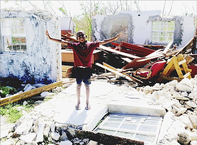 Amid the rubble of Crooked Island, the grandson of Janiemae Farquharson, pastor of St John the Baptist Church in Colonel Hill, manages a smile in difficult times. The church suffered extensive damage to its roof and electrical and sound systems. If people wish to donate to the church, contact Patrick Farquharson at 558-1842. For the full story, see page six. 