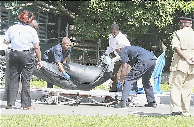 The body of a man is removed from the scene of a shooting on Tonique Williams Darling Highway yesterday. Photo: Tim Clarke/Tribune Staff